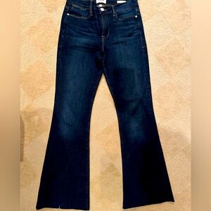 Women’s FRAME high-wasted flare  dark denim jeans with fringed/unfinished hem.